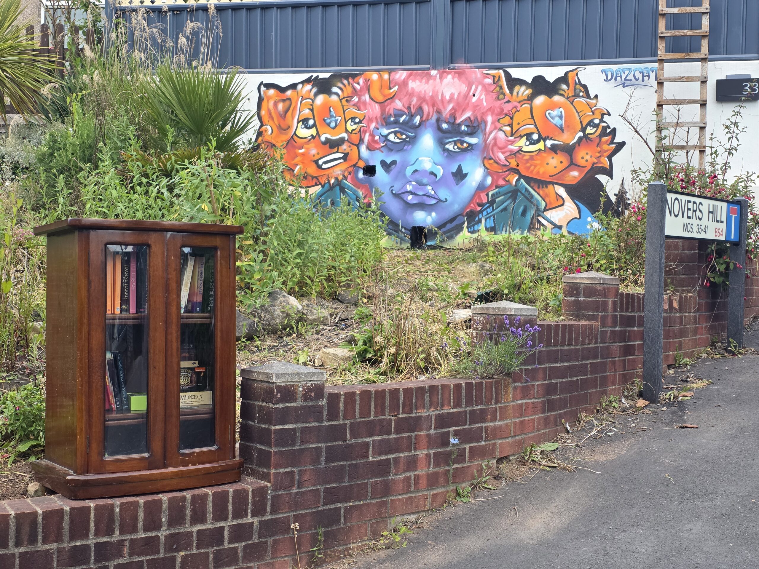 colourful street art on a wall and book swap cabinet