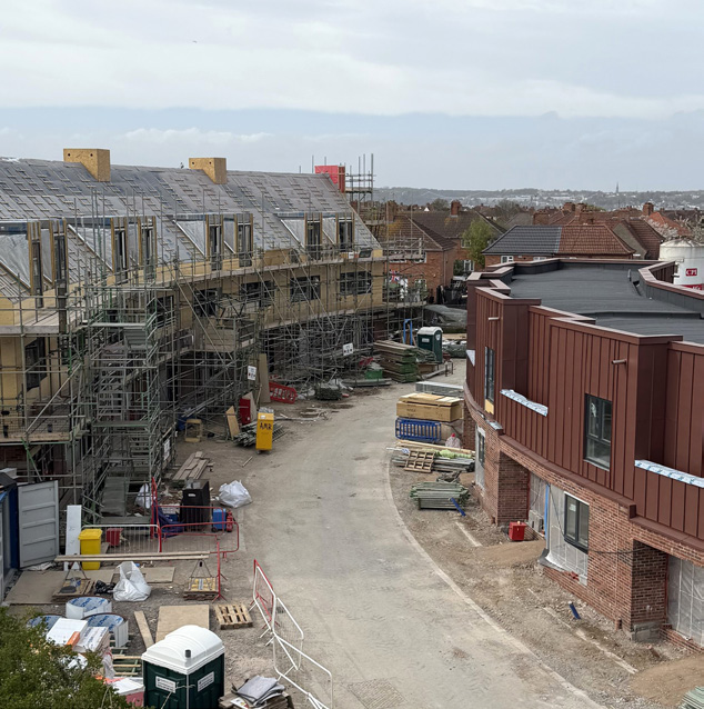 ariel photo of Old Cinema site showing a row of houses covered in scafolding and opposite a row of brown clad houses.